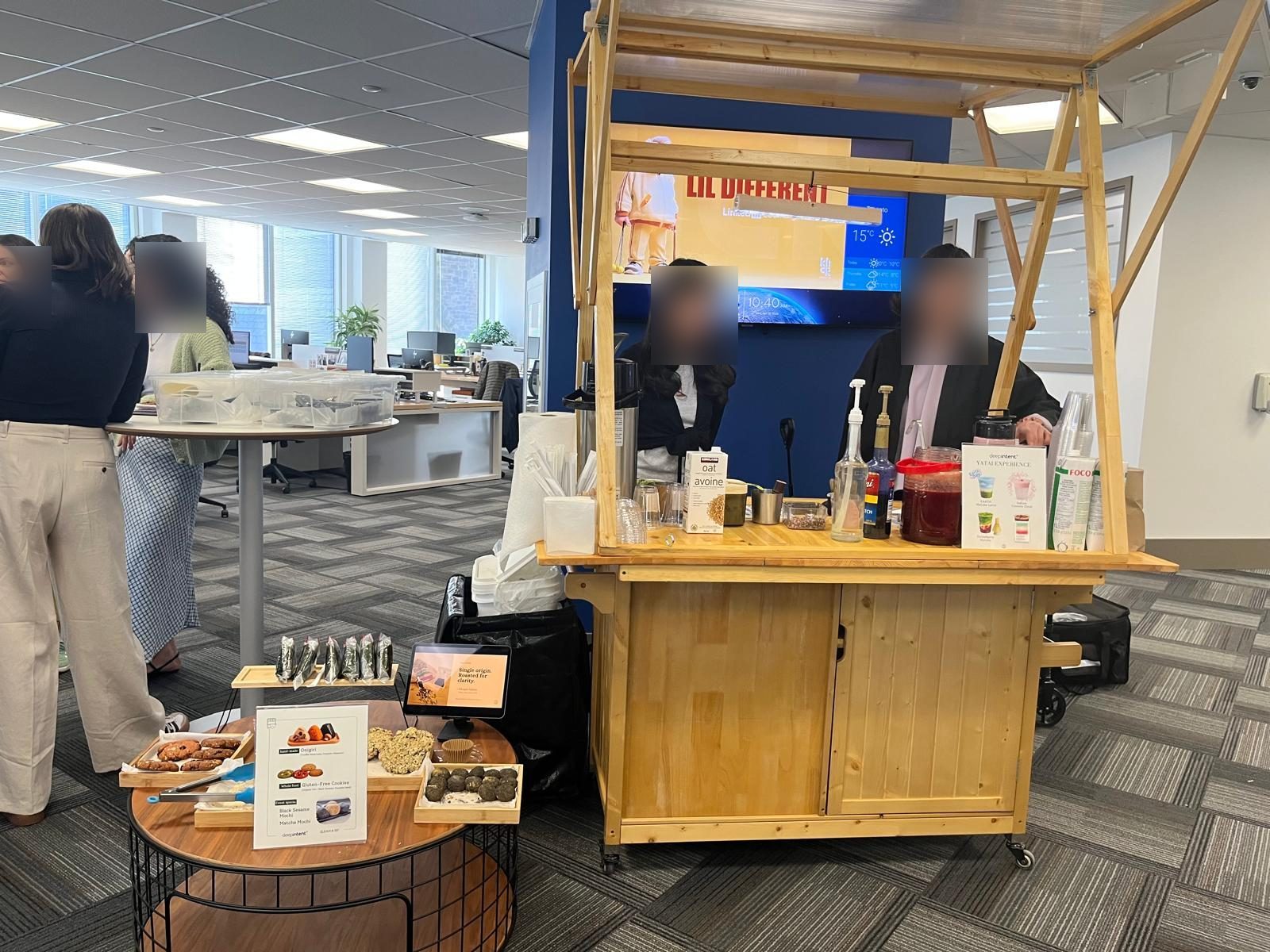 The Gleam & Sip matcha cart set up for DeepIntent's Yatai Experience in their Toronto office, with a spread of onigiri, gluten-free cookies and mochi